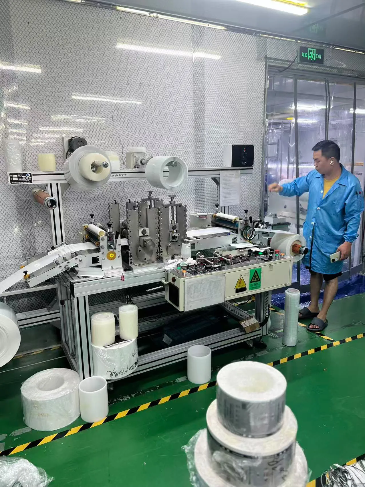 Team member beside roll-fed factory equipment